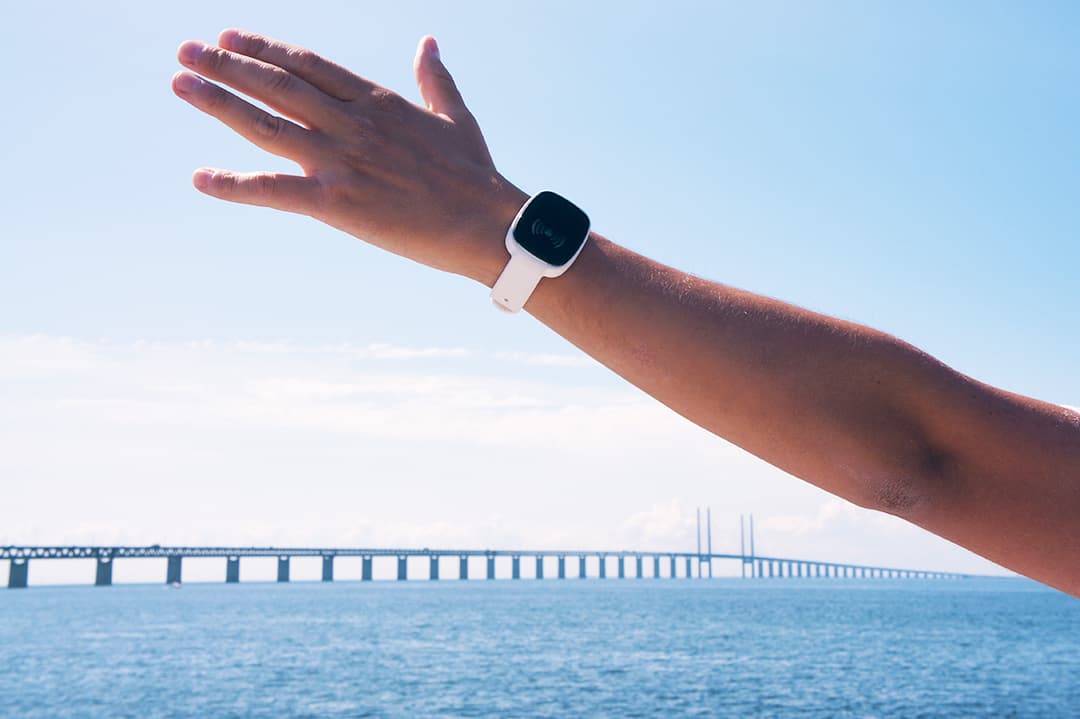 Person wearing TM-Alert while reaching out over an ocean bridge view